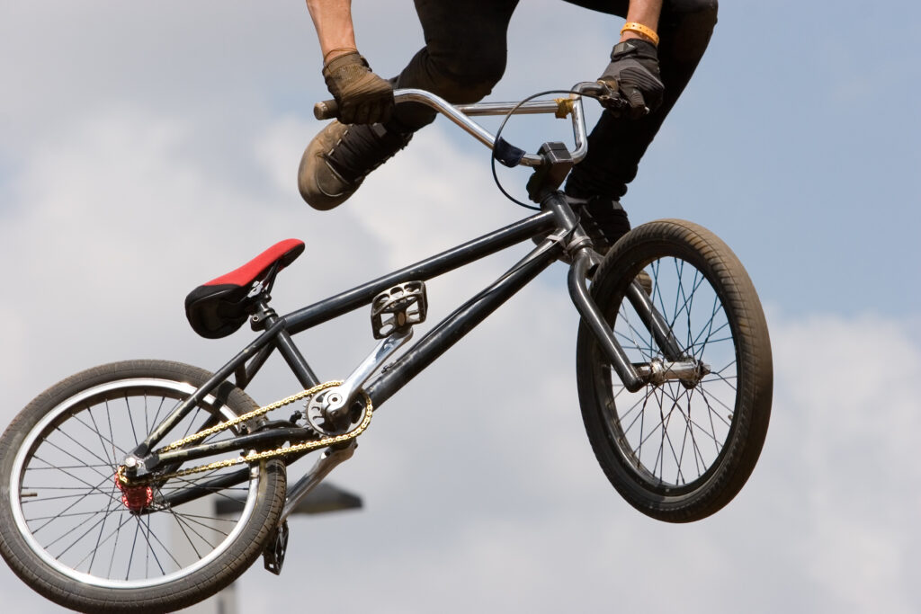 A BMX (Bicycle Moto-cross(X)) in the air against a clouded sky